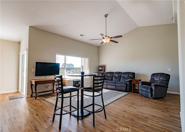 living room with wood-type flooring, vaulted ceiling, and ceiling fan