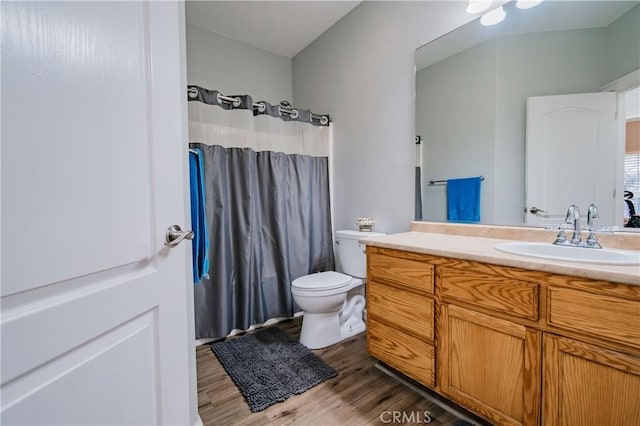 bathroom featuring hardwood / wood-style floors, vanity, toilet, and curtained shower