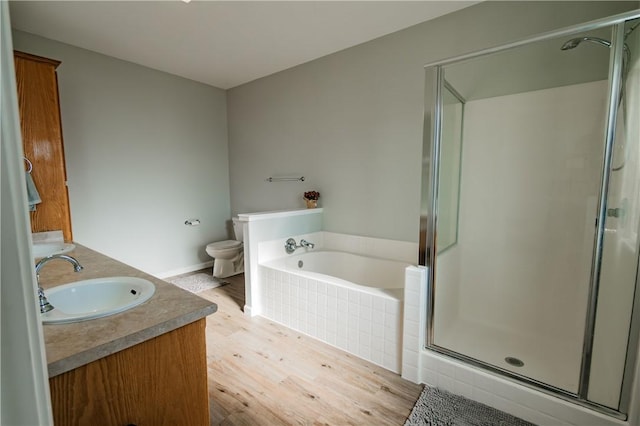 full bathroom with wood-type flooring, vanity, toilet, and separate shower and tub