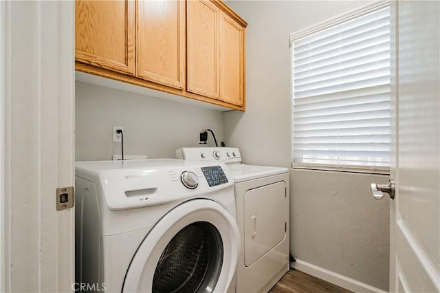 washroom featuring dark hardwood / wood-style floors, cabinets, and washing machine and clothes dryer