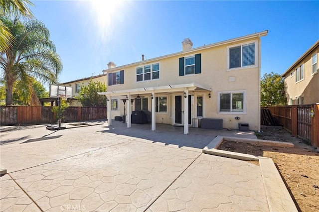 back of property with a pergola and a patio area