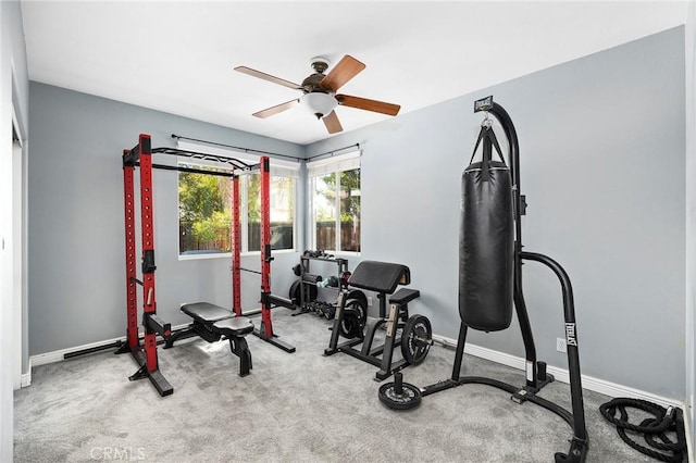 workout room with ceiling fan and light carpet