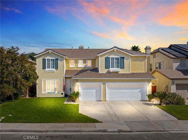 front facade with a garage and a yard