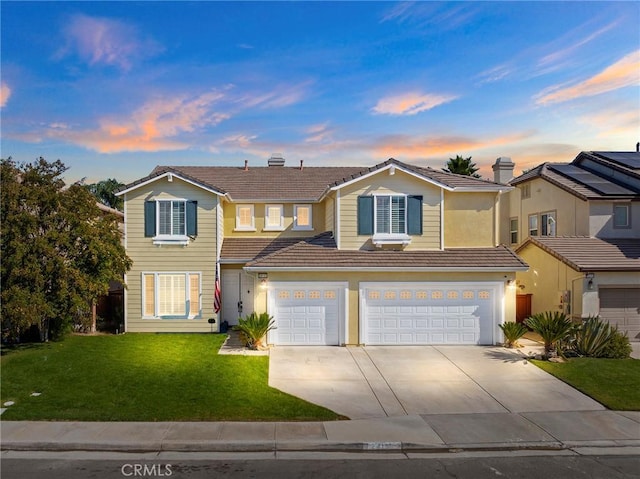 front of property featuring a garage and a yard