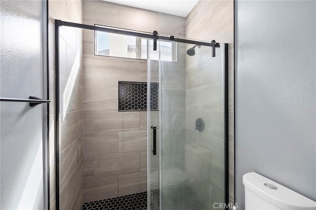 bathroom with an enclosed shower and toilet