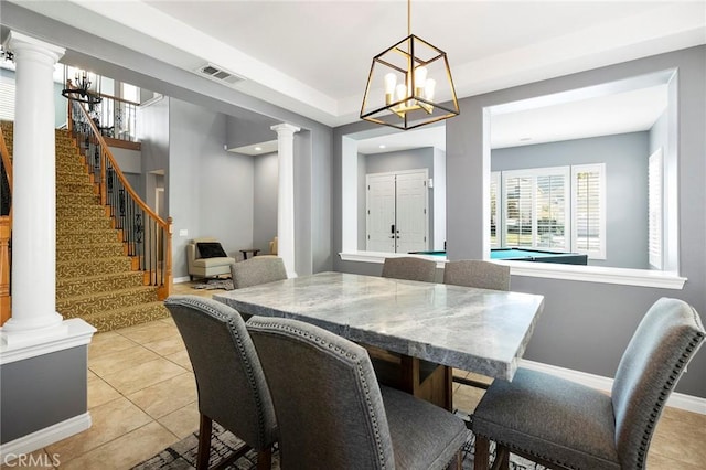 dining room featuring light tile patterned floors and ornate columns