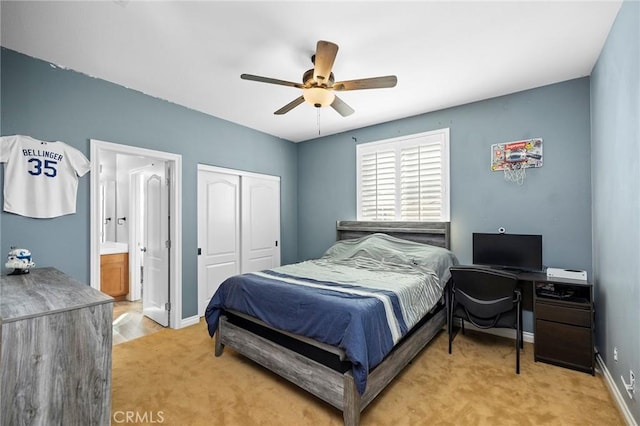 bedroom with ceiling fan, ensuite bathroom, a closet, and light colored carpet