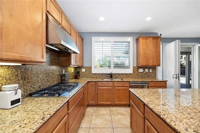 kitchen with light stone countertops, stainless steel appliances, tasteful backsplash, sink, and light tile patterned flooring