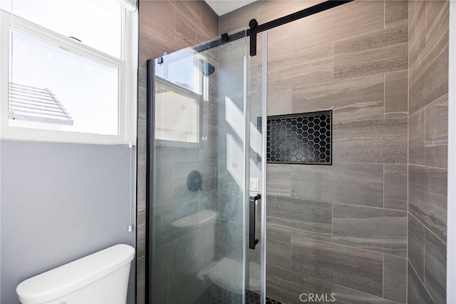 bathroom featuring an enclosed shower and toilet