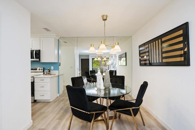 dining room featuring a chandelier and light hardwood / wood-style flooring