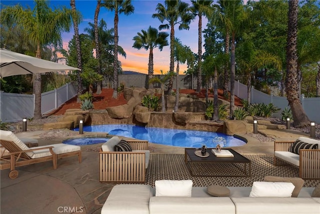 pool at dusk featuring a patio