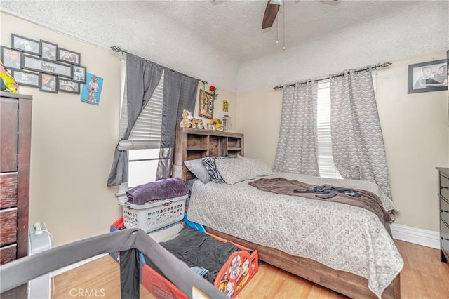 bedroom featuring ceiling fan, a textured ceiling, and hardwood / wood-style flooring