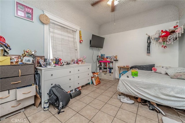 tiled bedroom featuring ceiling fan and a textured ceiling