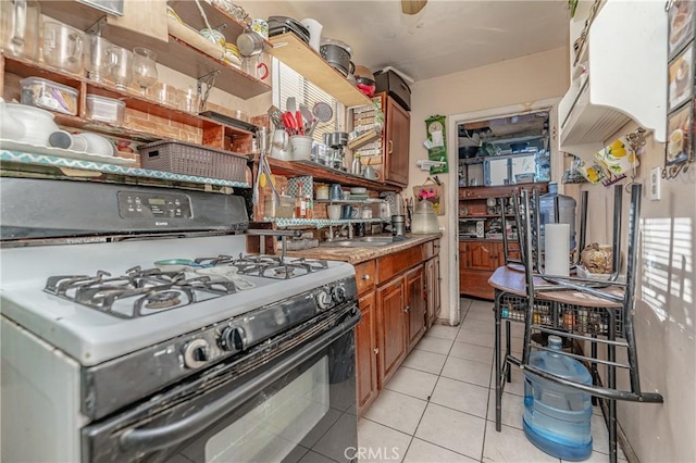 kitchen with light tile patterned floors and black range with gas cooktop