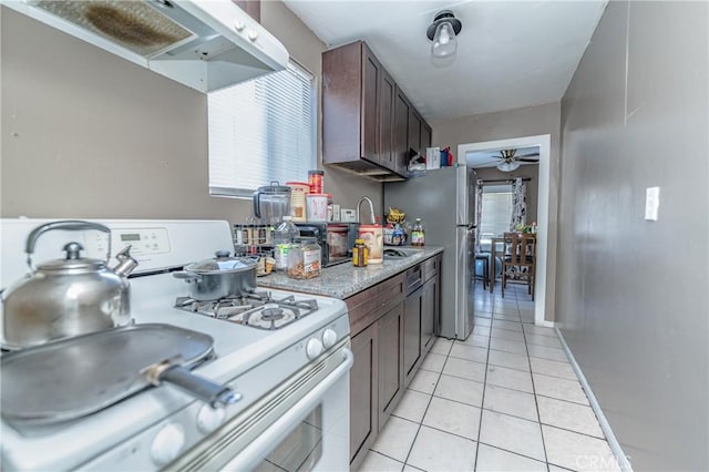 kitchen featuring ceiling fan, electric range, ventilation hood, dark brown cabinets, and light tile patterned flooring