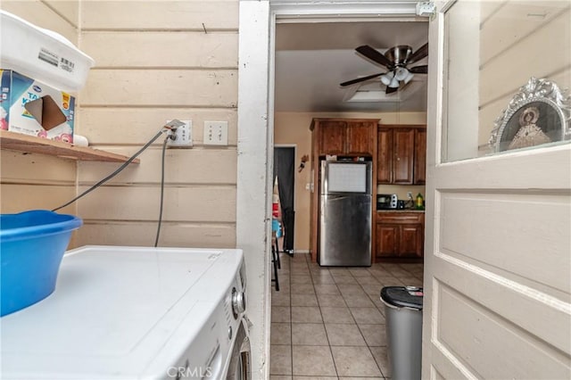 laundry area featuring light tile patterned floors, washing machine and dryer, and ceiling fan