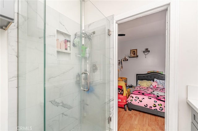 bathroom featuring wood-type flooring, vanity, and walk in shower