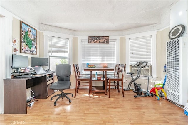 office area featuring light wood-type flooring and a textured ceiling