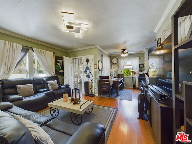 living room featuring a wealth of natural light, hardwood / wood-style floors, ceiling fan, and crown molding