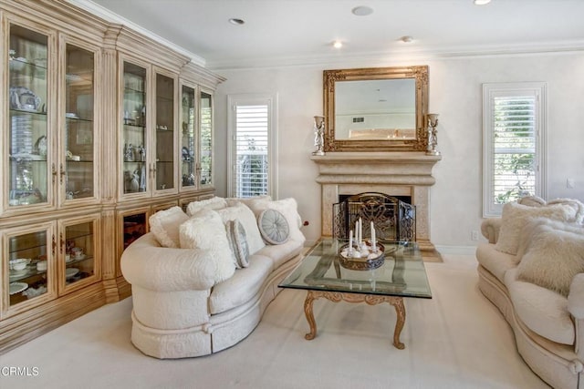 sitting room featuring crown molding, a high end fireplace, and light colored carpet