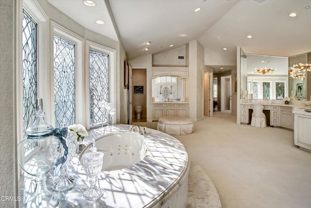 bathroom with toilet, plenty of natural light, lofted ceiling, and a washtub