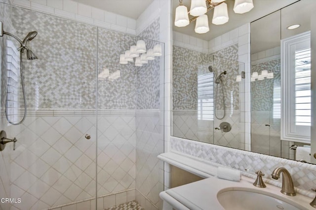 bathroom with tiled shower and vanity