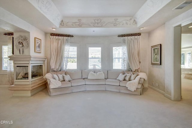 unfurnished living room with carpet, a tray ceiling, and plenty of natural light