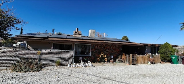 back of house featuring solar panels