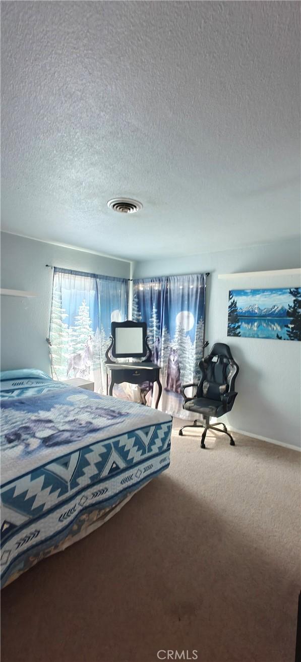 bedroom featuring carpet floors and a textured ceiling