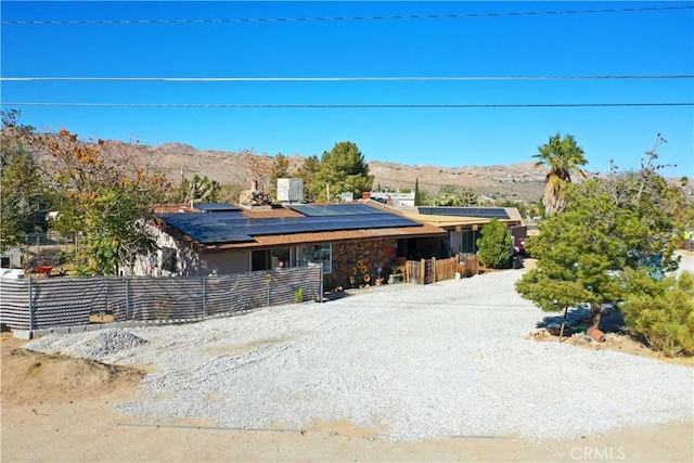 view of front of house with a mountain view and solar panels