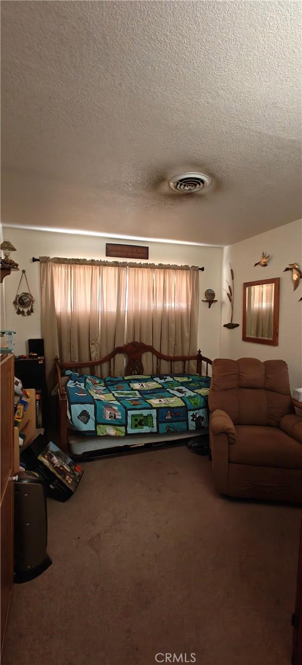 carpeted bedroom featuring a textured ceiling