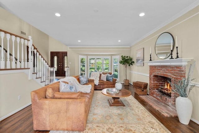 living room with dark hardwood / wood-style flooring, a brick fireplace, and ornamental molding