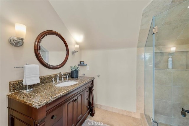 bathroom with tile patterned floors, vanity, a shower with shower door, and lofted ceiling