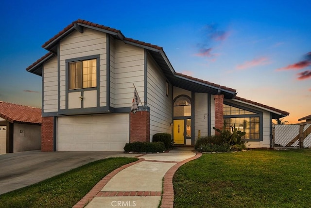 view of front of property with a garage and a yard