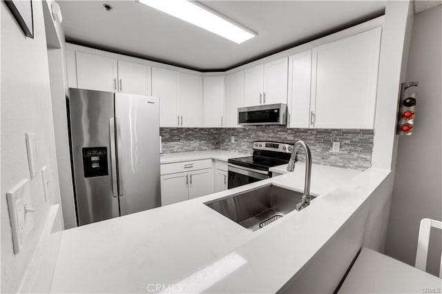 kitchen featuring sink, white cabinetry, decorative backsplash, and stainless steel appliances