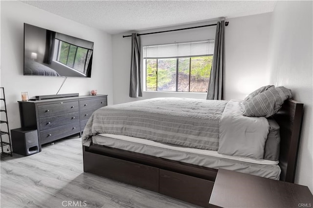 bedroom featuring a textured ceiling and light wood-type flooring