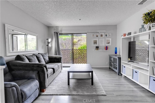 living room featuring a textured ceiling and light hardwood / wood-style flooring