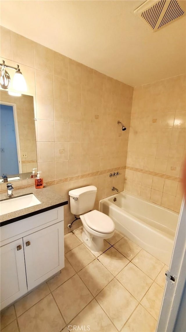 full bathroom featuring tile patterned floors, vanity, toilet, and tile walls