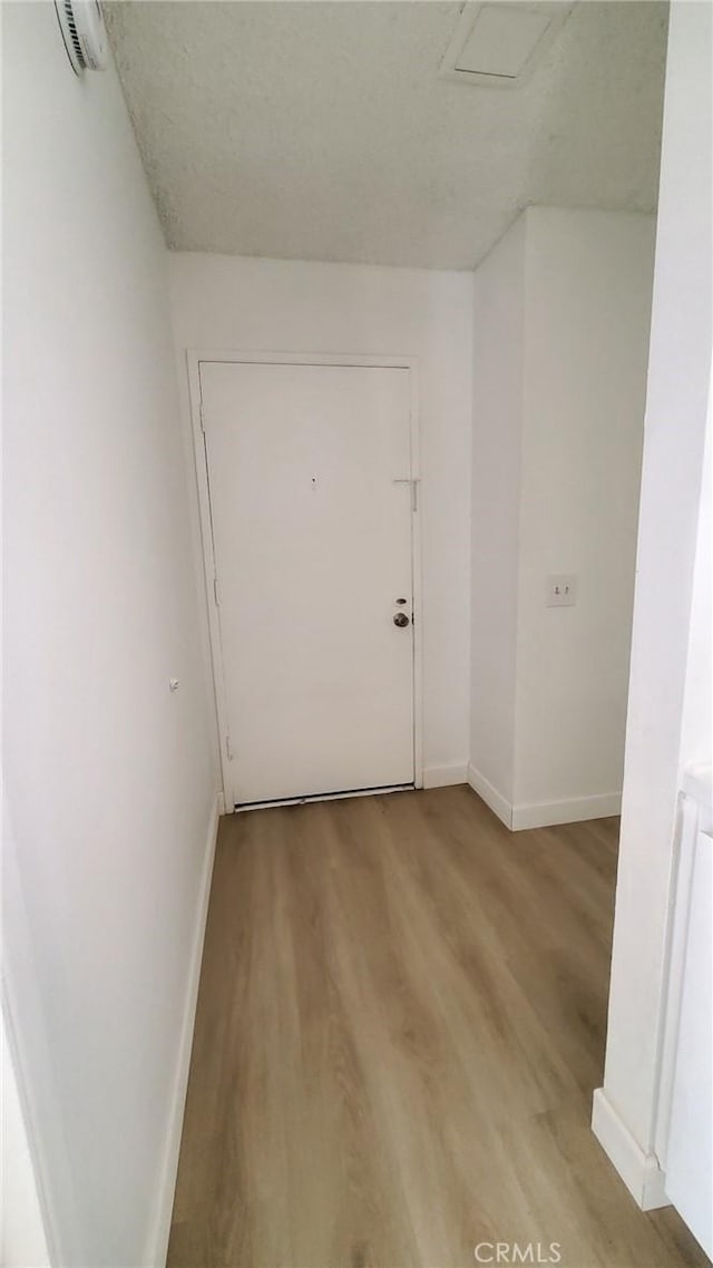 empty room featuring a textured ceiling and light hardwood / wood-style floors