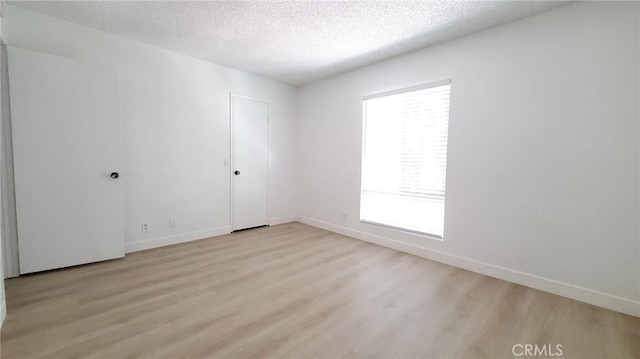 empty room featuring light hardwood / wood-style floors and a textured ceiling