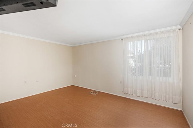 empty room with wood-type flooring and ornamental molding