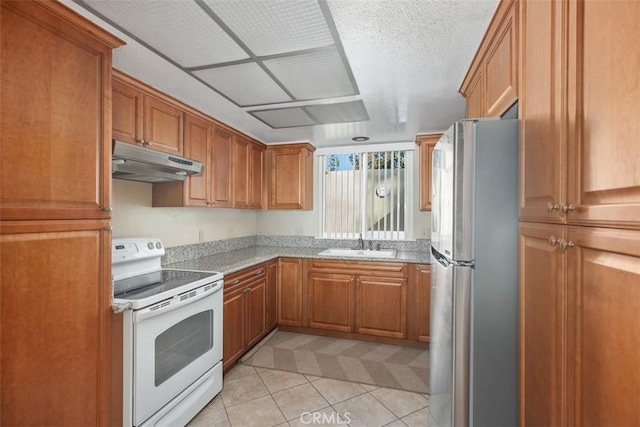 kitchen featuring sink, light stone countertops, light tile patterned floors, white electric range oven, and stainless steel refrigerator