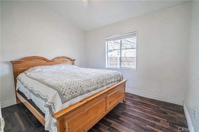 bedroom with lofted ceiling, a ceiling fan, dark wood-style floors, and baseboards