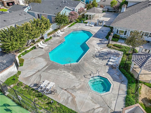community pool featuring fence, a gazebo, a patio, and a residential view