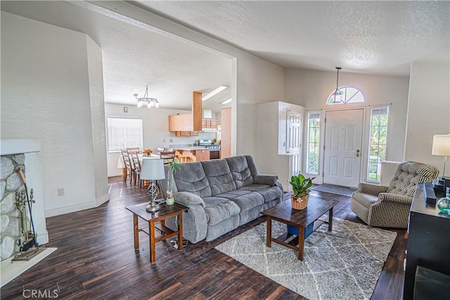 living room featuring baseboards, dark wood-style floors, a notable chandelier, a textured ceiling, and lofted ceiling