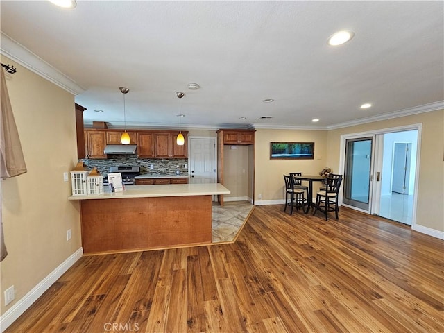 11881 Old Fashion Way, Garden Grove, CA 92840 - kitchen featuring a peninsula, brown cabinets, hardwood / wood-style flooring, under cabinet range hood, and crown molding