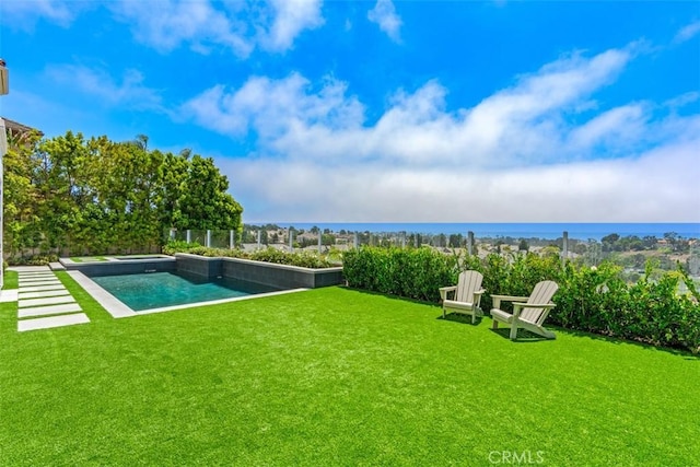 view of swimming pool featuring a yard and a water view