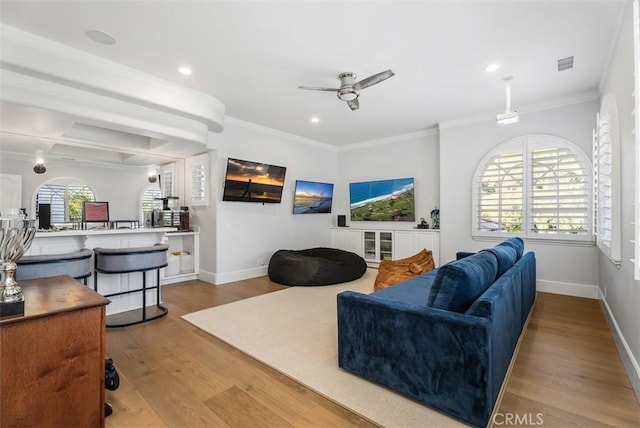 living room featuring ceiling fan, crown molding, and light hardwood / wood-style flooring