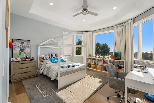 bedroom featuring a tray ceiling, ceiling fan, and dark hardwood / wood-style floors