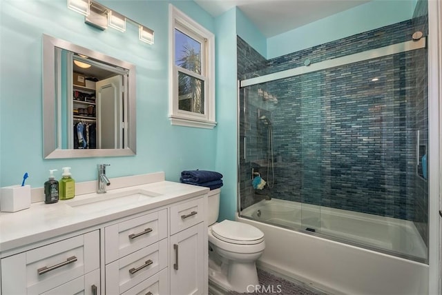 full bathroom featuring vanity, bath / shower combo with glass door, and toilet